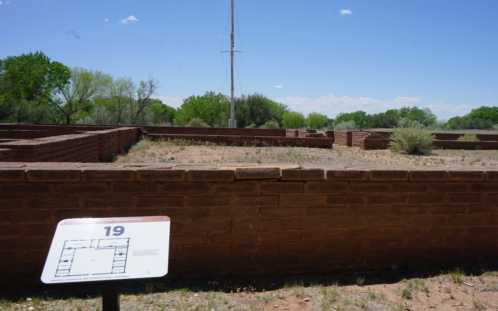 Bosque Redondo Memorial Audio Tour Stop 19, Fort reconstruction and flag pole in the foreground.